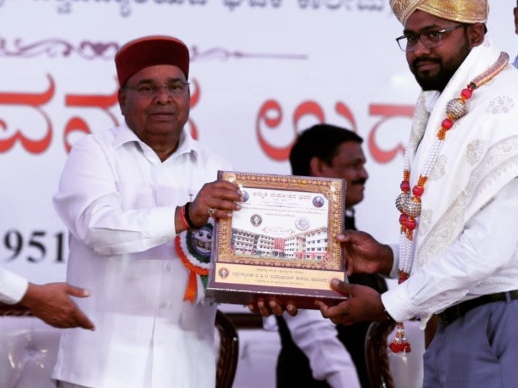 A memento being presented on stage at a second felicitation event.