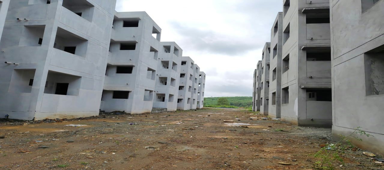 Housing blocks standing as bare concrete frames on the 976 house project at Dharwad.