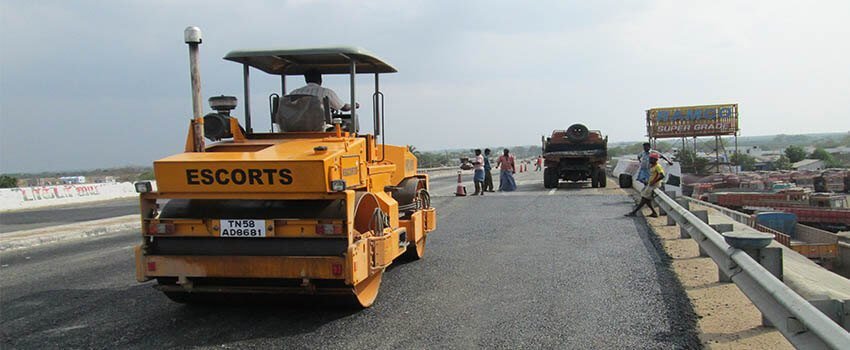 A roller compacting the finished carriageway.